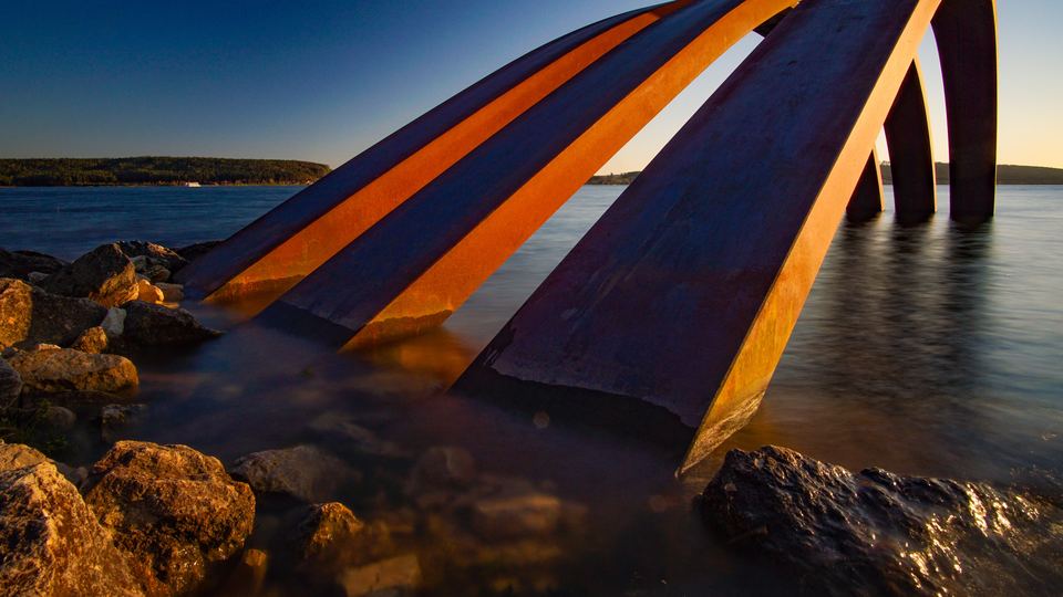 Geschwungene Holzbögen der Skulptur am Ufer des Großen Brombachsees im Abendlicht